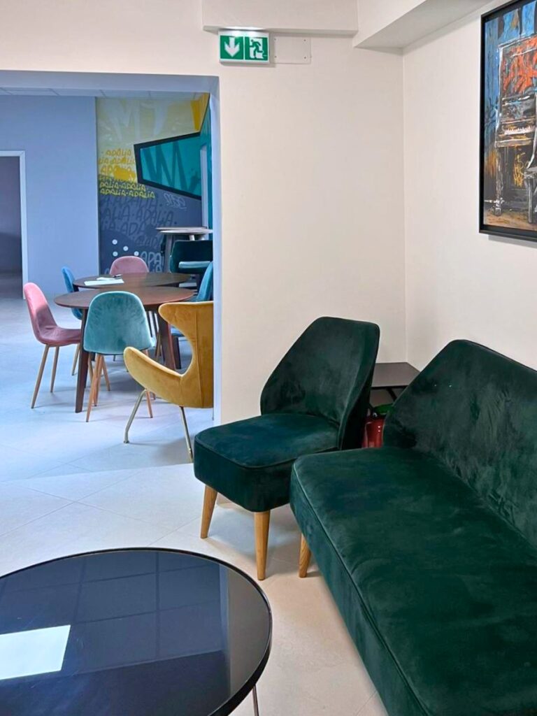 Coin salon avec fauteuils verts et table basse dans les locaux d’Adalia