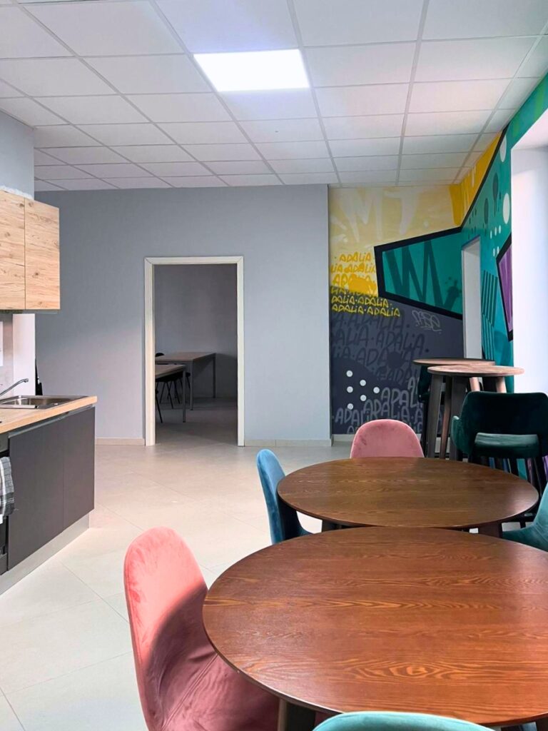 Vue depuis la cuisine vers le mur graphique et l’espace détente d’Adalia
