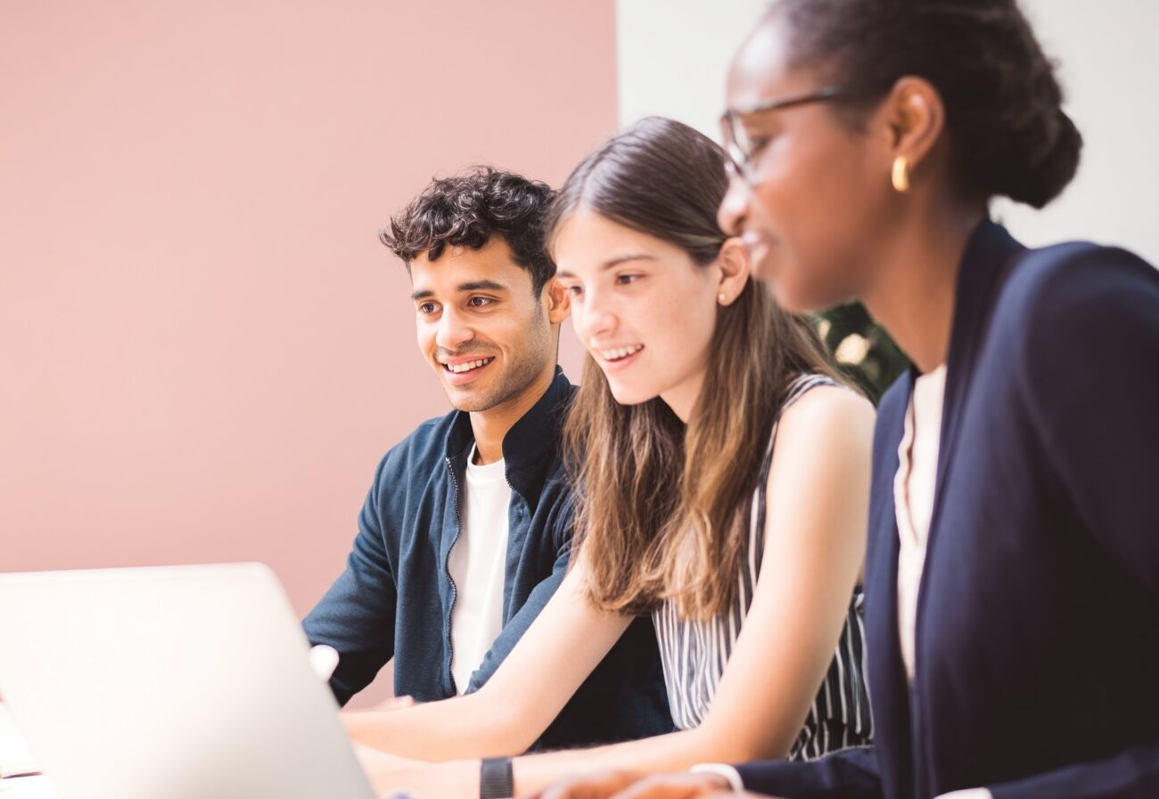 Jeunes adultes en situation professionnelle dans un bureau, illustrant la candidature à une formation en alternance chez Adalia School
