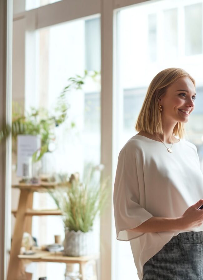 Conseillère de vente accueillant un client dans un magasin moderne